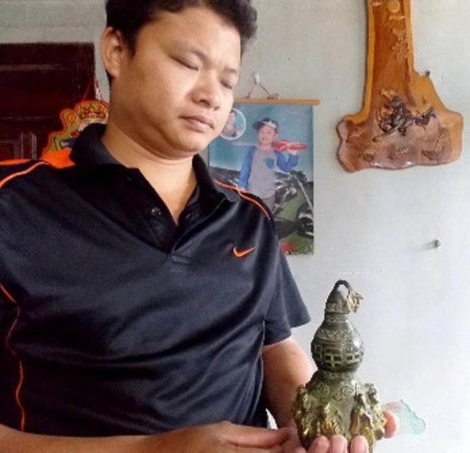 Anh Trần Công Viên đang cầm trên tay chiếc bình hồ lô được cho là cổ vật.