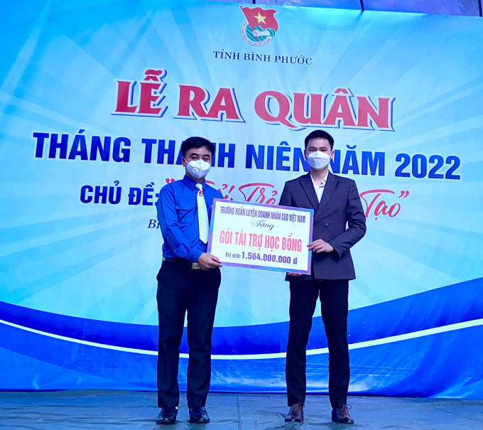 Anh Lục Văn Phương - Giám đốc Dự án hướng nghiệp toàn quốc, Trường Huấn luyện Doanh nhân CEO Việt Nam (phải) trao bảng tượng trưng các nguồn lực hỗ trợ cho học sinh Bình Phước.