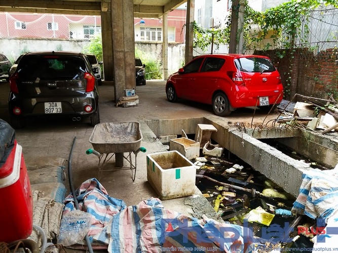 Rác ngập tràn trên mặt nước, vât liệu nằm ngổn ngang, bên cạnh là hàng trăm chiếc ô tô mới toanh.