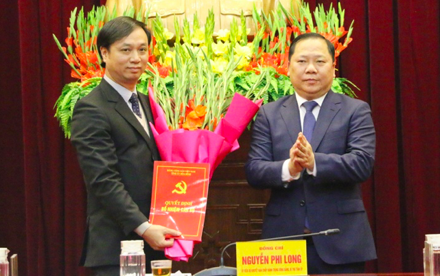 Bí thư Tỉnh ủy Hòa Bình Nguyễn Phi Long trao Quyết định và tặng hoa chúc mừng cho ông Phạm Anh Quý, Phó Bí thư Thành ủy, Chủ tịch UBND thành phố Hòa Bình. Ảnh: Trung Hoài.