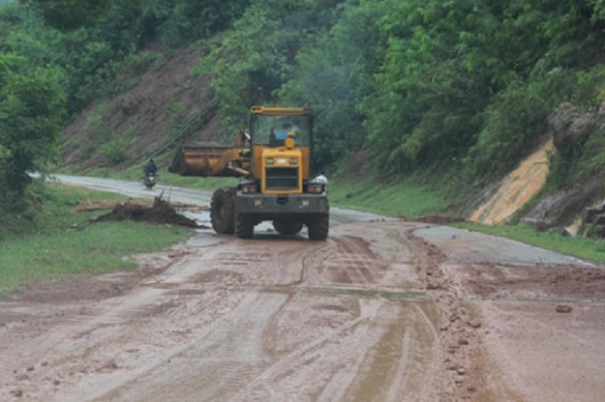 Máy xúc của Công ty CP đường bộ 224 dọn đất đá và bùn thải trên mặt đường QL6.