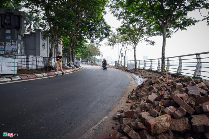 Vỉa hè ven hồ Tây được lật lớp gạch cũ để thay mới khiến người đi bộ phải đi xuống lòng đường.