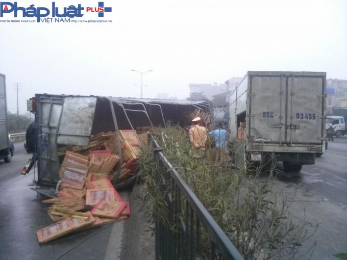 Hàng hóa trong xe tải đổ tràn lan ra đường.