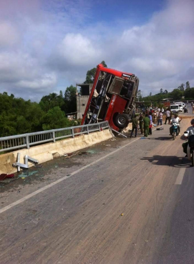 Xe khách đâm vào lan can, treo lơ lửng trên thành cầu.
