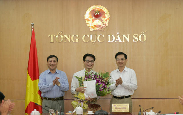 Lãnh đạo Tổng cục Dân số trao quyết định và hoa chúc mừng Phó Tổng biên tập Nguyễn Chí Long.