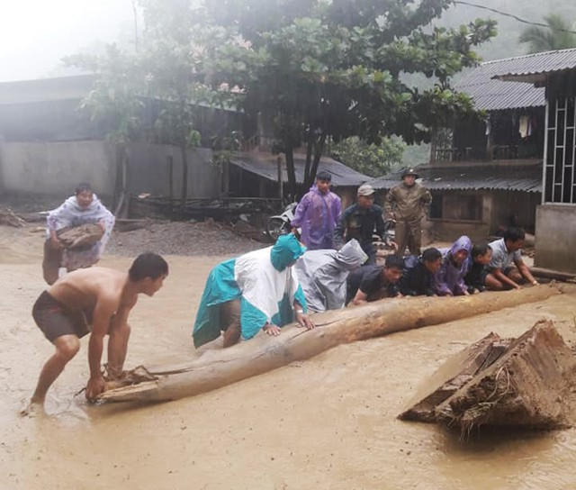 Người dân dùng thân gỗ lớn, đá tảng để chặn dòng chảy của cơn lũ hướng thẳng vào nhà dân.