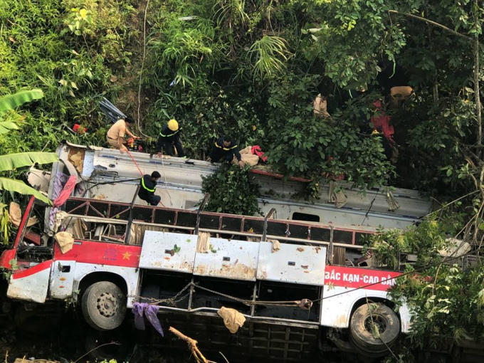 Các lực lượng chức năng chằng dây để kéo chiếc xe khách nằm dưới đáy vực ra khỏi hiện trường.