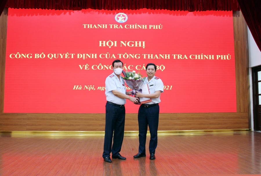 Tổng Thanh tra Chính phủ Đoàn Hồng Phong trao quyết định và tặng hoa chúc mừng tân Vụ trưởng Vụ I Dương Quốc Huy. Ảnh: PH