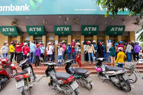 Dòng người tập trung trước trụ ATM ở khu chế xuất Tân Thuận, quận 7 chờ để rút tiền.