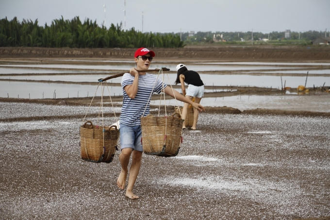 Hoàng Bách đang thực hiện thử thách gánh muối trong chương trình Gia Đình Vui Vẻ