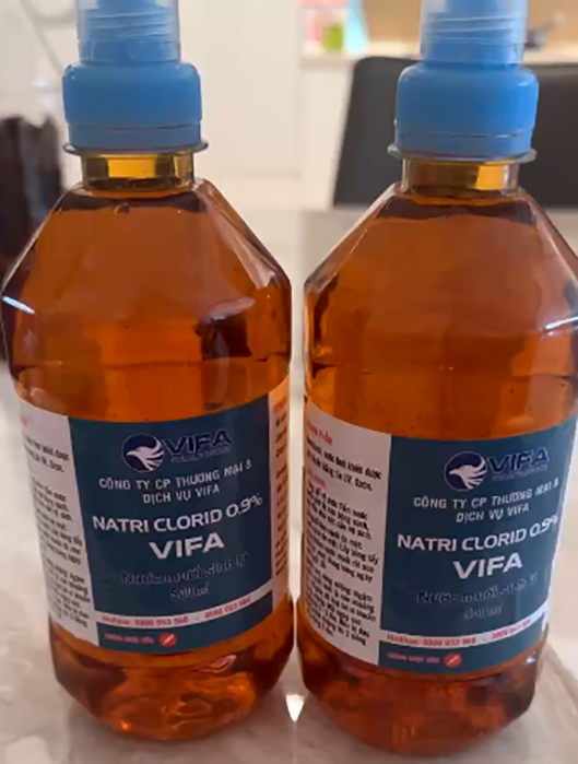 Hình ảnh 2 chai nước muối sinh lý dán nhãn Công ty cổ phần thương mại và dịch vụ VIFA. Ảnh: N.M.