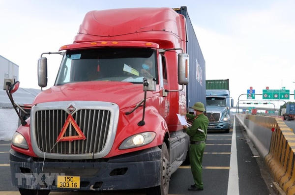 Lực lượng chức năng kiểm tra một phương tiện vận chuyển hàng hóa. (Ảnh: TTXVN)