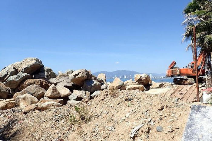 Máy xúc đưa đá đổ xuống vịnh Nha Trang. Ảnh Minh Ngọc.