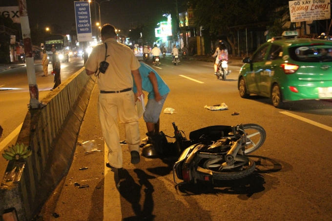 Chiếc xe máy dập nát cùng chuối và nhan ( bên trái ) được người dân mang ra đốt.