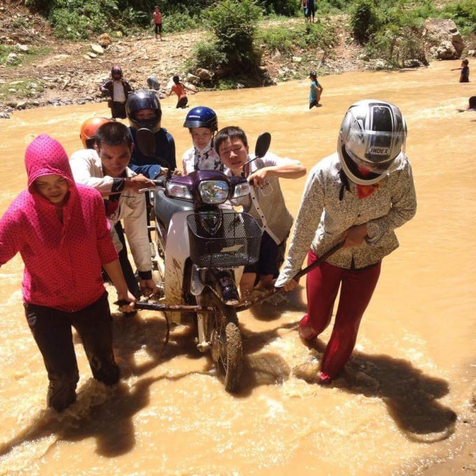 Phải nhờ sự trợ giúp của phụ huynh học sinh khiêng xe qua suối để kịp vào điểm trường chuẩn bị khai giảng.