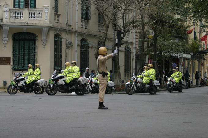 Cảnh sát giao thông hướng dẫn người tham gia giao thông đi, dừng khi có đoàn bảo vệ hội nghị đi qua.