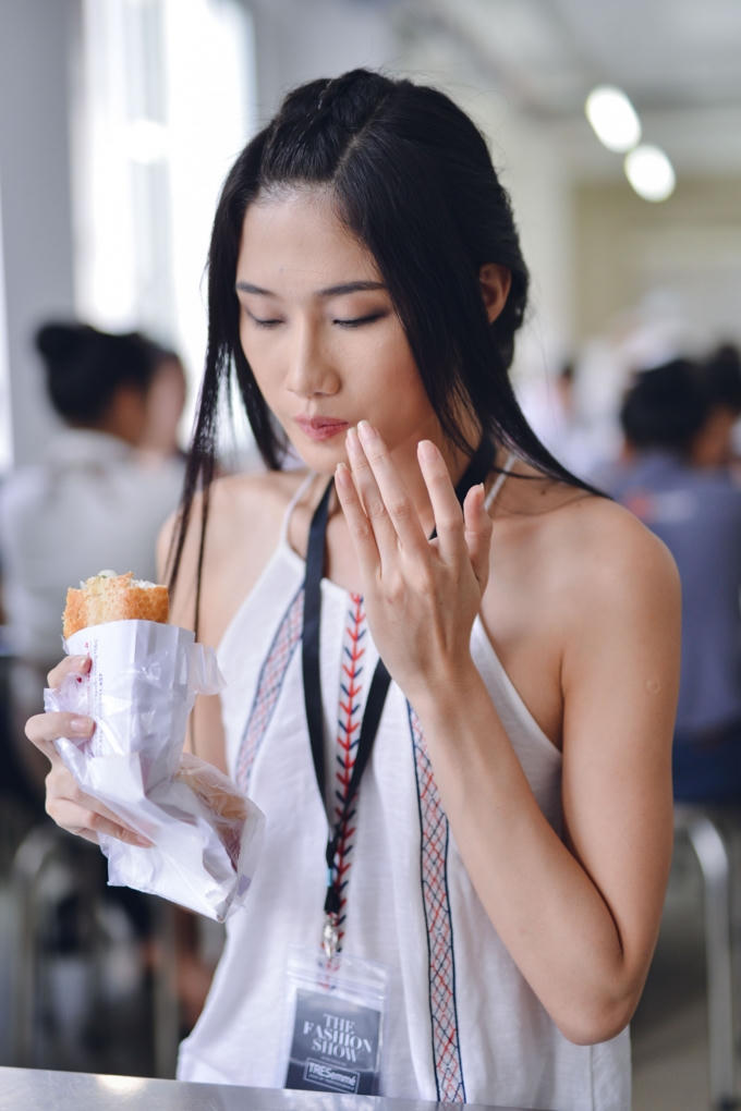 Buổi tổng duyệt kết thúc khá muộn vào 1h chiều, Kha Mỹ Vân dùng qua loa phần ăn trưa bên cạnh đồng nghiệp. Với ổ bánh mì ăn vội, vậy mà cô nàng 8x vẫn đầy năng lượng. (Photo: Nghĩa Ngô)