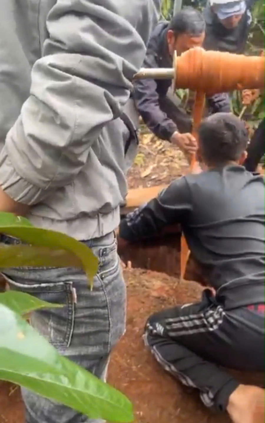 Người dân kịp thời kéo người phụ nữ từ giếng sâu lên trên bờ. Ảnh: Cắt từ Clip