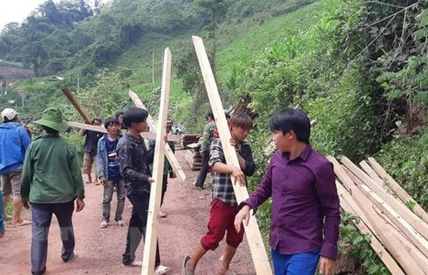 Lực lượng đoàn viên thanh niên Huyện đoàn Nậm Pồ tham gia tháo dỡ, vận chuyển nhà ở, tài sản cho các hộ dân nằm dưới cung trượt sạt ở bản Huổi Đắp (xã Nậm Tin, huyện Nậm Pồ, tỉnh Điện Biên). (Ảnh: TTXVN phát)
