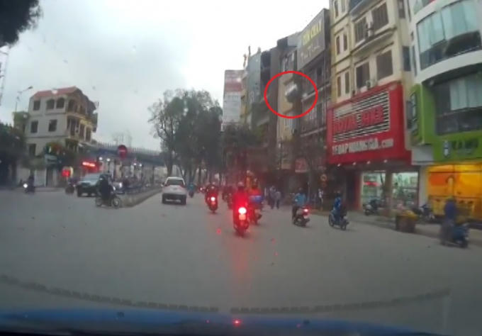 Chiếc thùng nước rơi tự do từ nóc tòa nhà xuống đường.