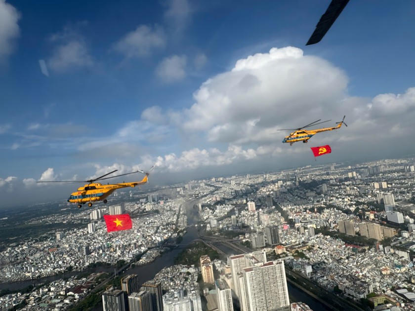 Trực thăng mang cờ Đảng, cờ Tổ quốc bay trên bầu trời trung tâm TP Hồ Chí Minh.