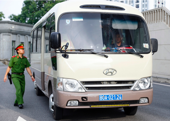 Hai xe 29 chỗ chở các bị cáo tới cơ quan xét xử, họ không qua cửa an ninh mà được dẫn giải thẳng lên phòng xử.