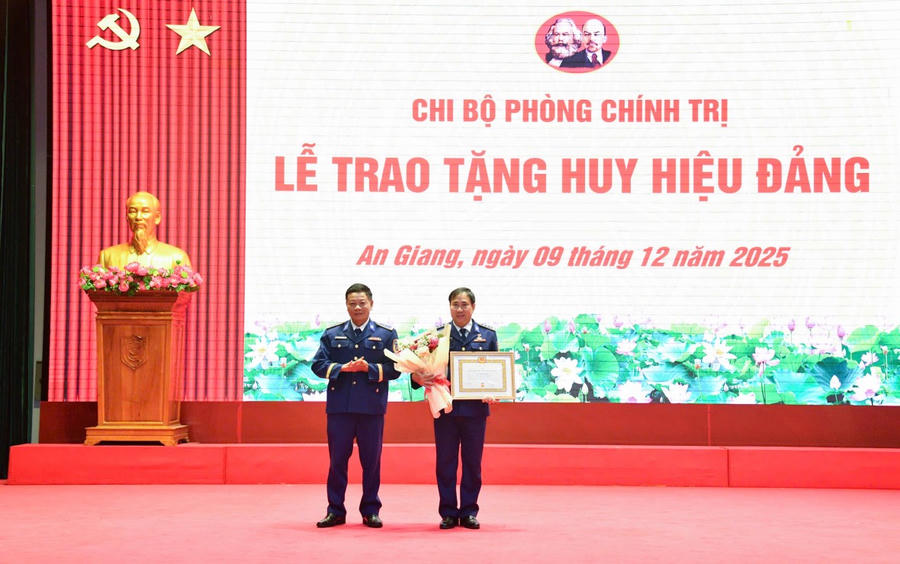 Đồng chí Đại tá Phan Duy Cường - Đảng ủy viên, Phó Tư lệnh Quân sự, Bộ Tư lệnh Vùng Cảnh sát biển 4 trao huy hiệu 30 năm tuổi Đảng và tặng hoa chúc mừng đồng chí Thượng tá Vũ Đình Diên