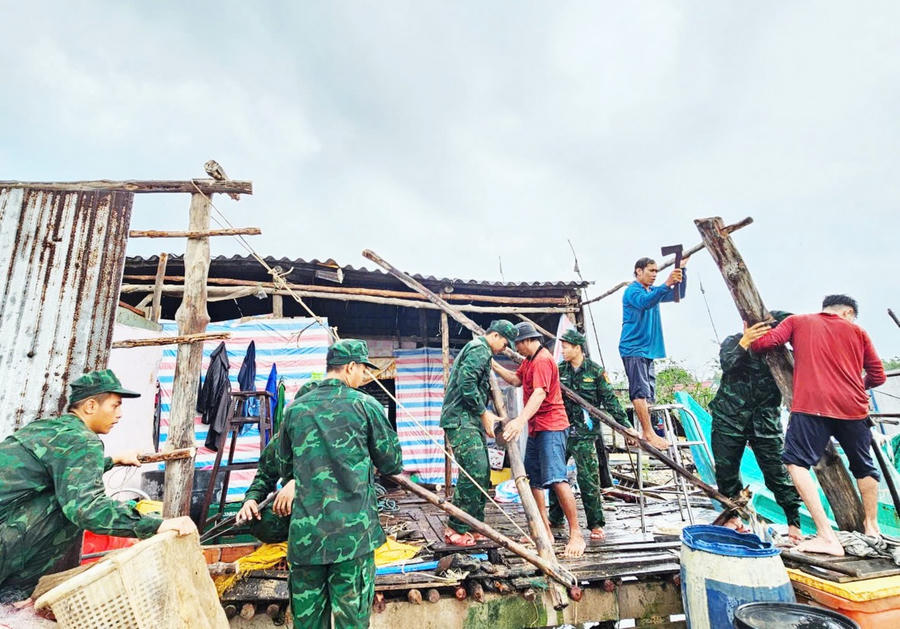 Cán bộ, chiến sĩ Đồn Biên phòng Đất Mũi phối hợp cùng các lực lượng địa phương hỗ trợ hộ ông Phù Văn Phương.