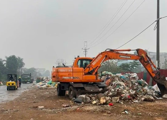 Máy múc được huy động để thu dọn lô bánh kẹo đổ thải trái phép.