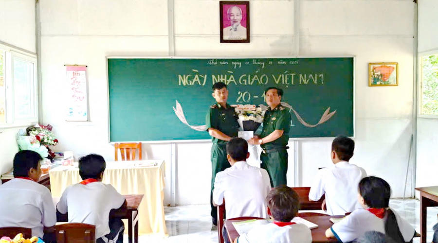 Đồn Biên phòng Hòn Chuối tặng hoa chúc mừng thầy Trần Bình Phục (bên trái) và các em học sinh nhân Ngày 20/11.