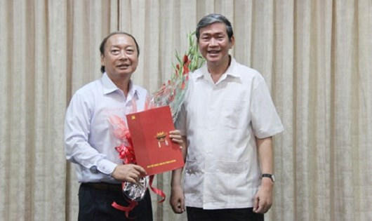 Đồng chí Đinh Thế Huynh (phải) trao quyết định và tặng hoa chúc mừng đồng chí Võ Văn Phuông.