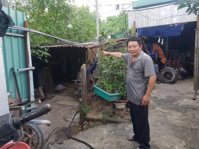 Ông Dư cạnh ngôi nhà của mình.