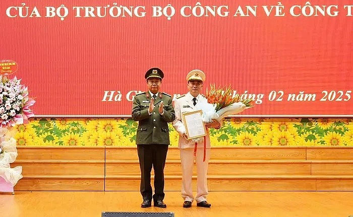 Giám đốc Công an tỉnh Hà Giang Nguyễn Đức Thuận trao quyết định và tặng hoa chúc mừng thượng tá Nguyễn Mạnh Hùng. (Ảnh: Công an tỉnh Hà Giang).