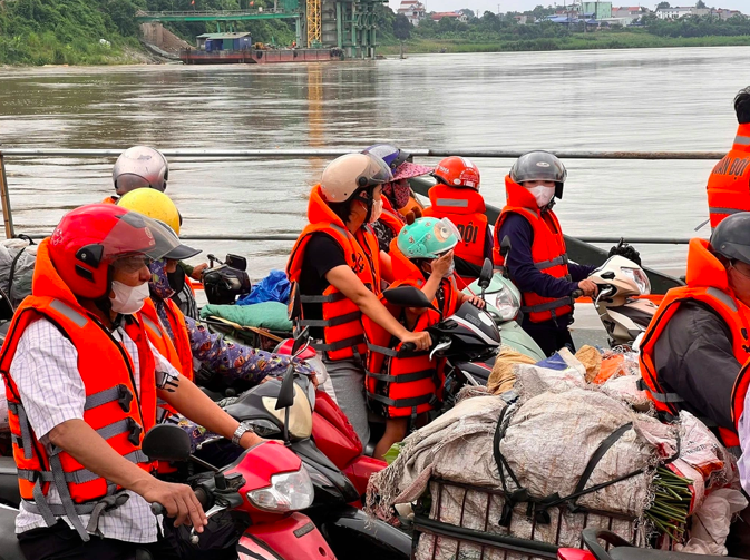 Người dân đi bộ hoặc đi xe máy sẽ phải mặc áo phao khi lưu thông bằng phà quân sự (Ảnh: Đăng Chiến).