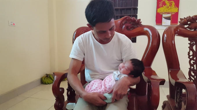 Anh Đàm Văn Hưởng (chồng sản phụ Nguyễn Thị K.) phải ở nhà chăm con sau khi vợ mất. Ảnh: Huy Trung
