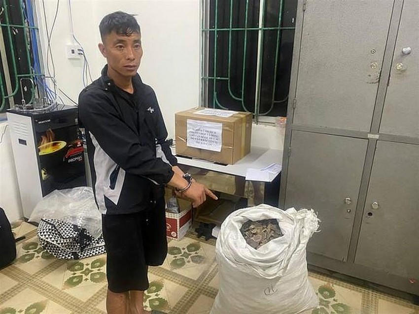 Đối tượng Nông Văn Anh và tang vật là bao vảy tê tê. (Ảnh: Công an Cao Bằng).