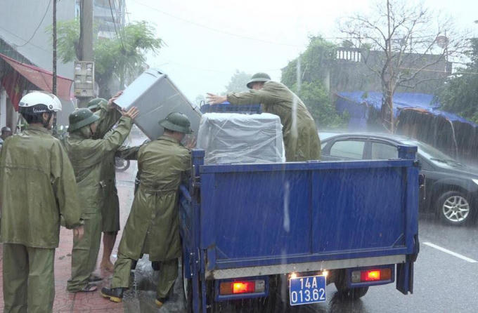 Lực lượng chức năng dùng xe chuyên dụng di chuyển tài sản của người dân đến nơi an toàn.
