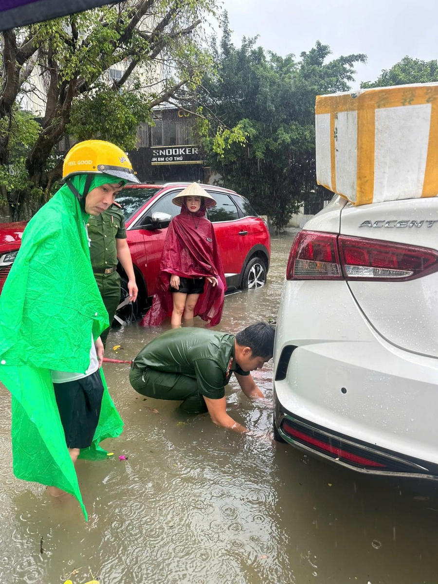 Dầm mưa hỗ trợ người dân.