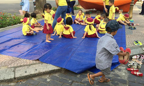 Cậu bé ve chai xếp dép cô giáo để vỉa hè khi đưa học sinh dã ngoại. (Ảnh Facebook Nghia Pham).