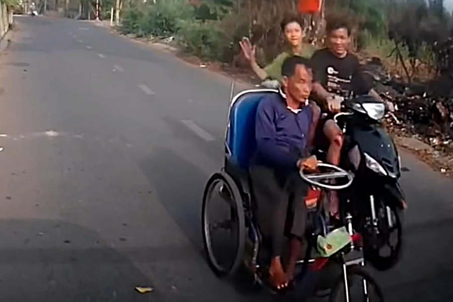 Hai thanh niên đi xe máy dùng tay tát vào đầu của người đàn ông đi xe lăn với thái độ đùa giỡn