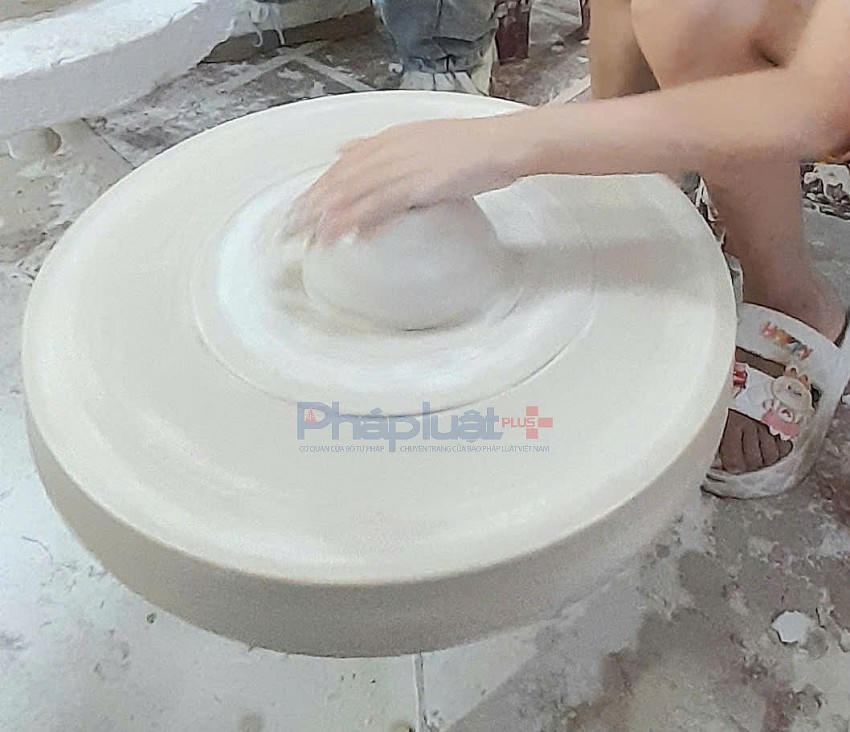 Du khách tự tay thực hiện việc làm gốm bằng bàn xoay.