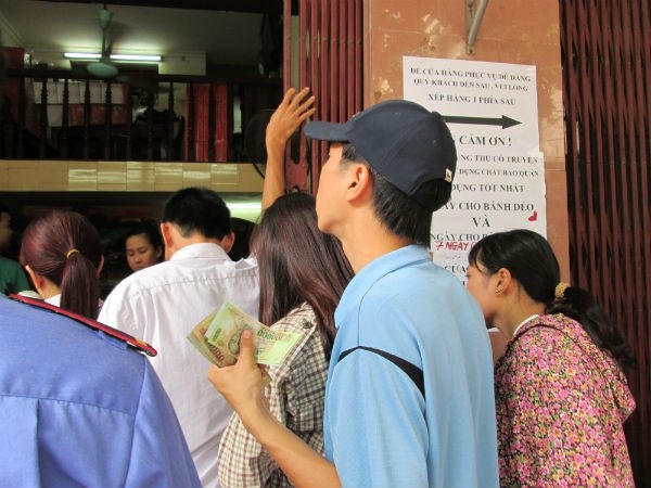 Có người còn chuẩn bị tiền trước để đến khi mua bánh thì trả ngay để tiết kiệm thời gian cho mình và cho người khác. Ảnh: Diệu Thuỳ.