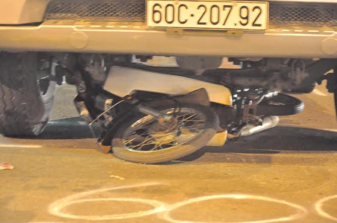 Xe máy nằm bẹp dí dưới gầm xe container.