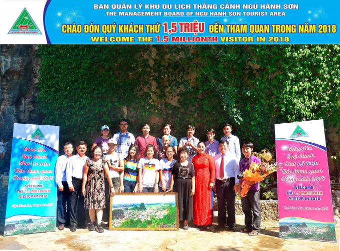 Chủ tịch quận Ngũ Hành Sơn Nguyễn Thị Anh Thi (áo đỏ) tặng hoa cho đoàn du khách thứ 1,5 triệu đến Khu danh thắng. Ảnh: Ngọc Nhất.