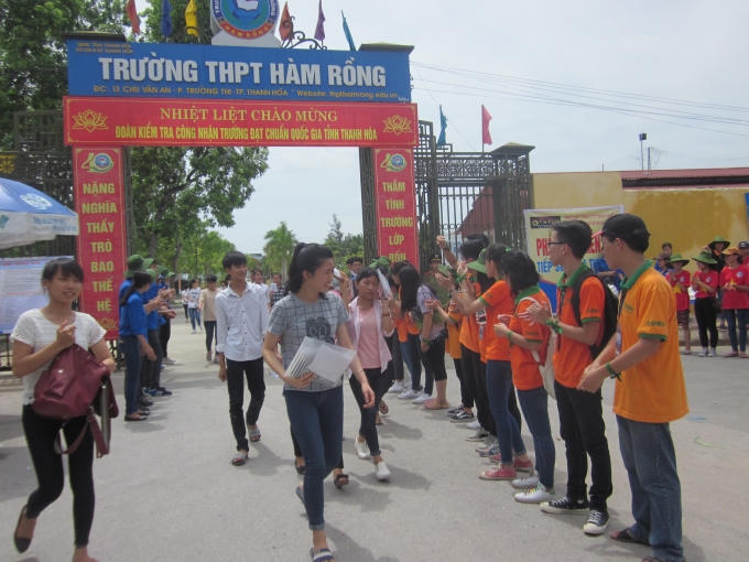 Thí sinh bước ra khỏi cổng trường trong sự chào đón nhiệt tình của tình nguyện viên