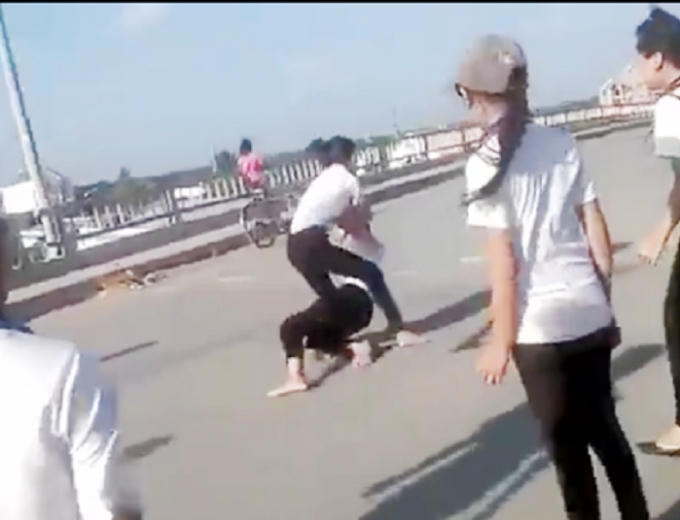 Hai nữ sinh đánh nhau có sự cổ vũ của nhiều học sinh khác.