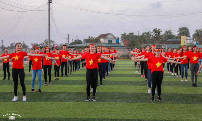 Tại trường Đại học Hà Tĩnh, hàng trăm sinh viên và giáo viên mặc áo đỏ, sao vàng tập trung tại sân vận động trình diễn các điệu nhảy cổ động cho các cầu thủ của chúng ta.