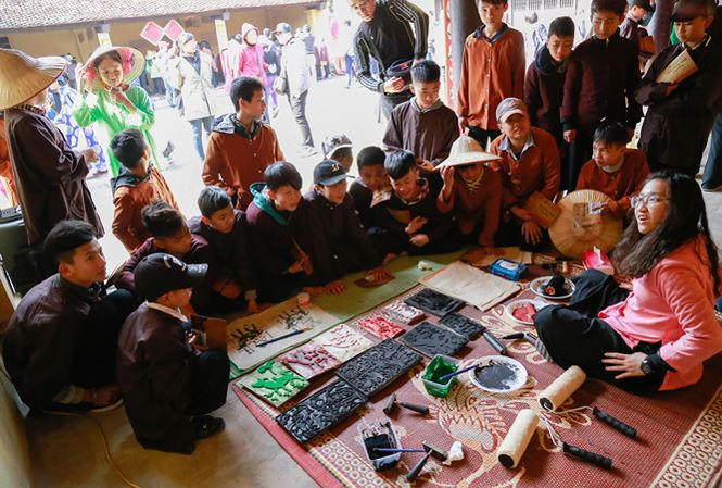 Học sinh hào hứng với tranh Đông Hồ. Ảnh: Nghiêm Huê.