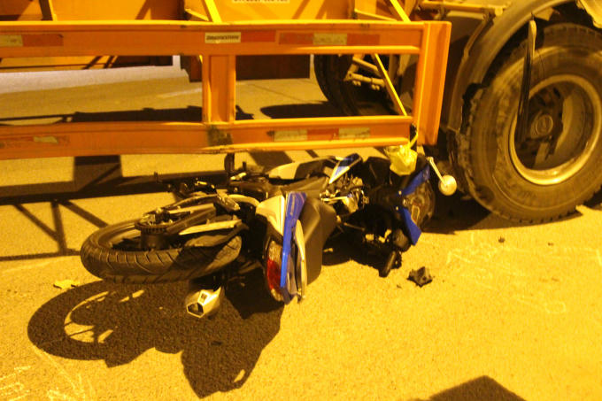 Xe máy lọt dưới gầm xe container.