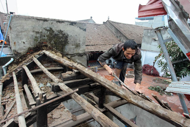 Một gia đình ở thôn Quan Độ đang sửa lại mái nhà đã bị sức ép của vụ nổ thổi bay toàn bộ ngói lợp.